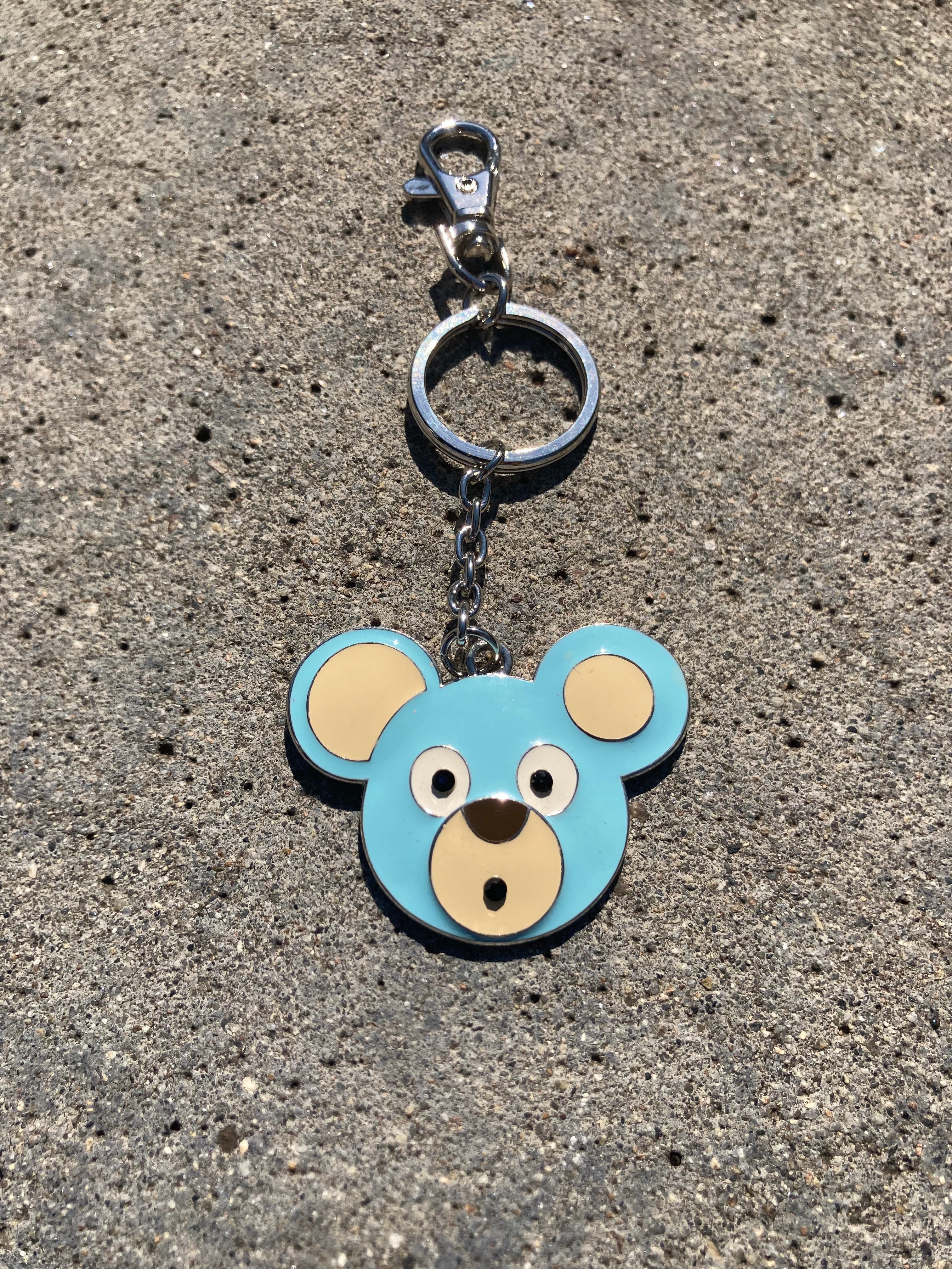O. Bear keychain with bear face design on a textured surface