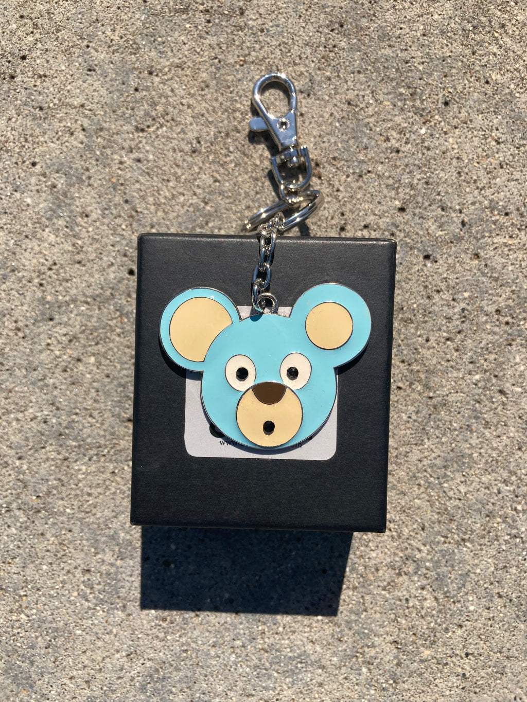 O. Bear keychain with bear design on a black square background