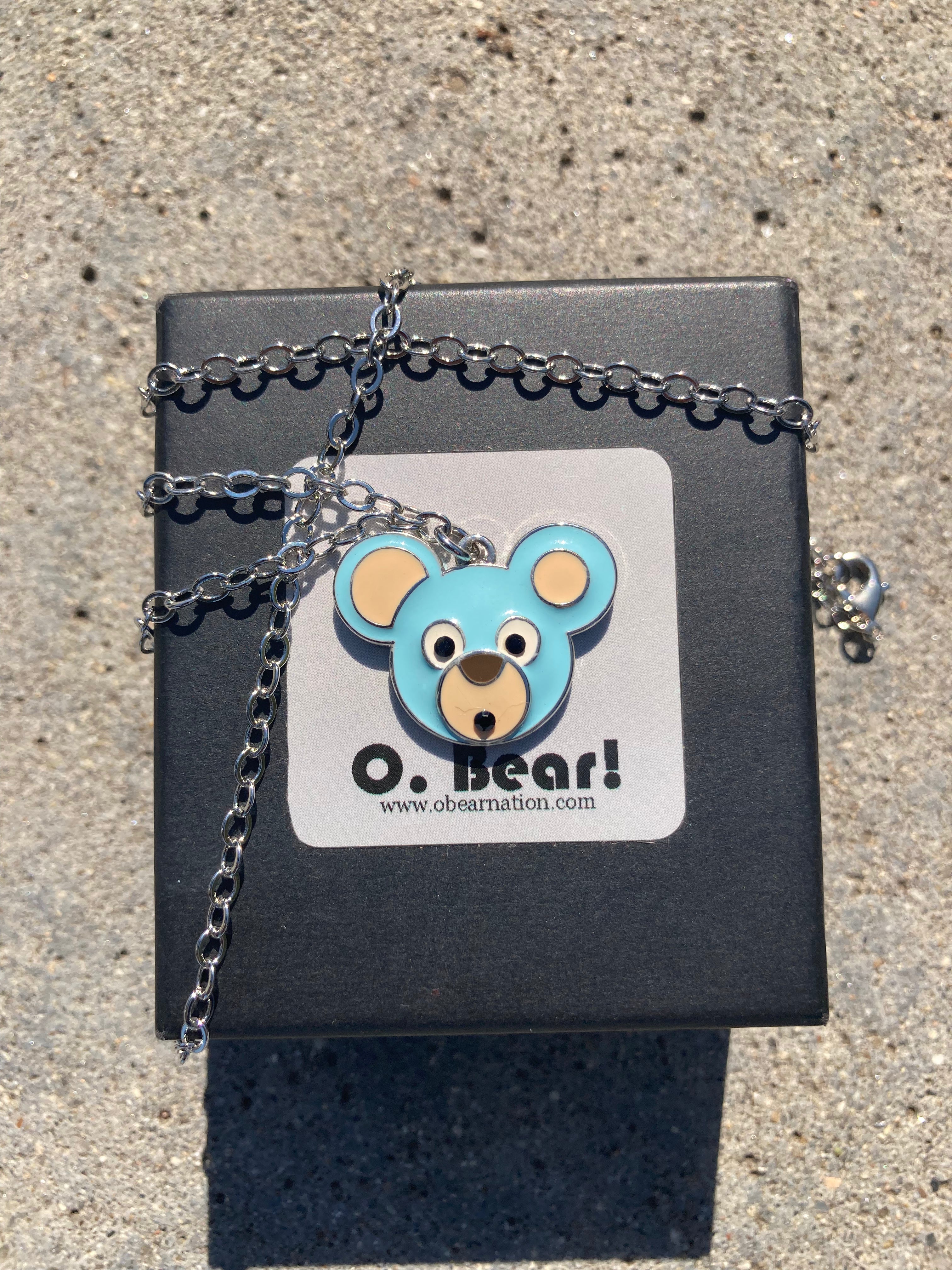 Necklace with a bear pendant on a black box with 'O. Bear!' branding.